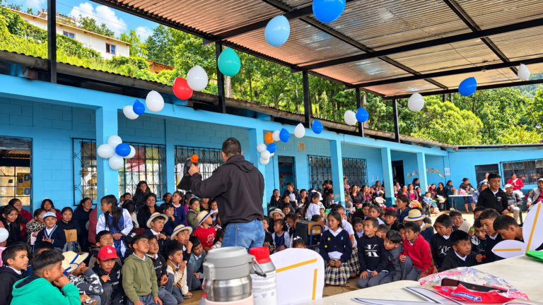 Asamblea escolar bajo globos coloridos